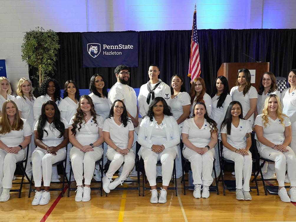 Group of practical nurses in rows on a hardwood gymnasium floor.