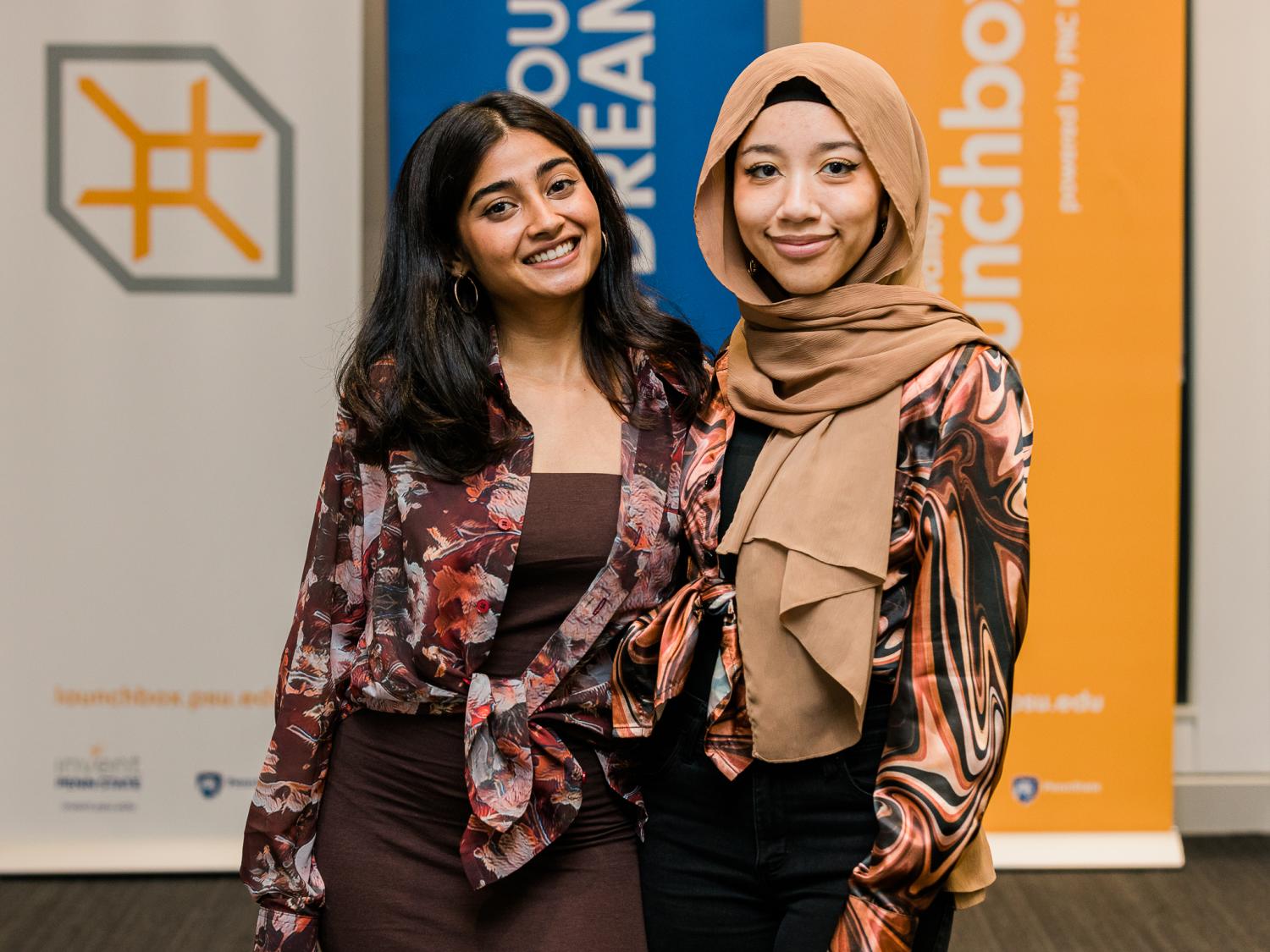 Two students standing in front of Happy Valley LaunchBox powered by PNC Bank signage