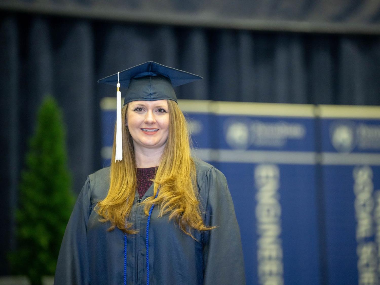 Brittany Anderson, a Penn State World Campus graduate who earned degrees in accounting and finance, poses before Penn State Behrend's December commencement program.