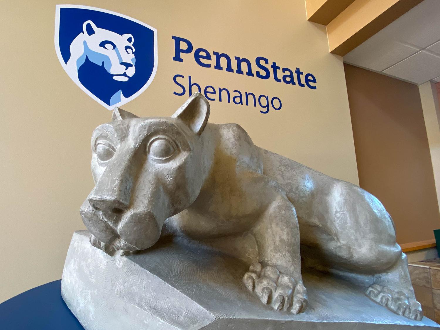 Lion Shrine posed in front of Penn State Shenango logo