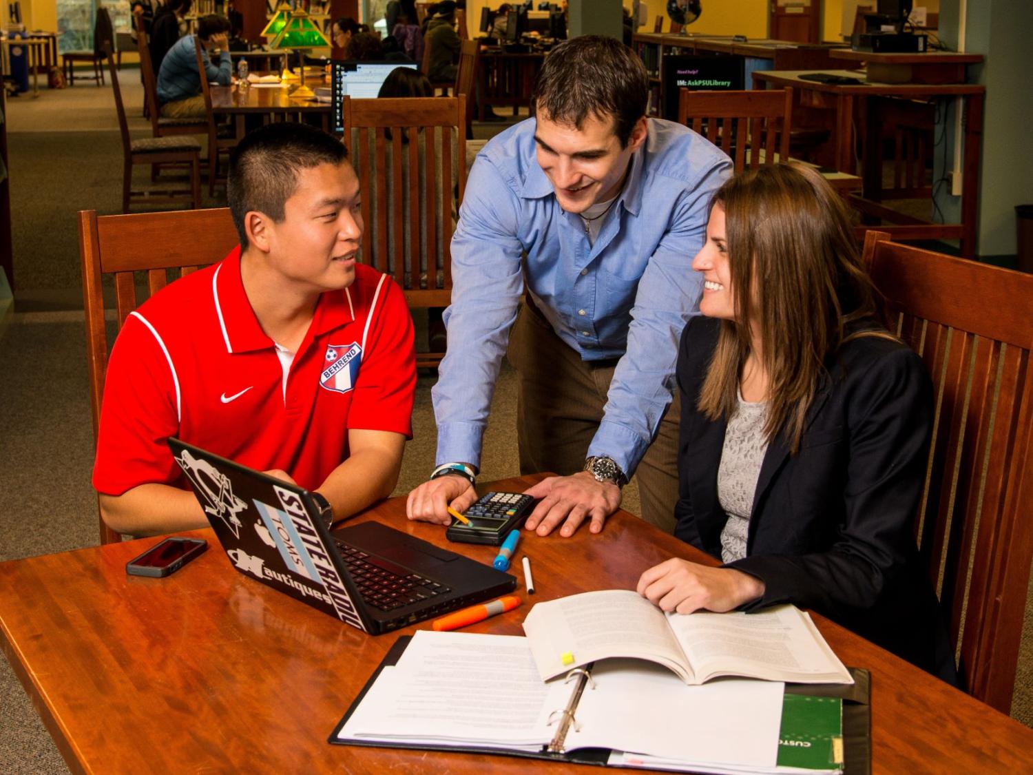 Three students in the MBA program collaborate in Lilley Library at Penn State Behrend.