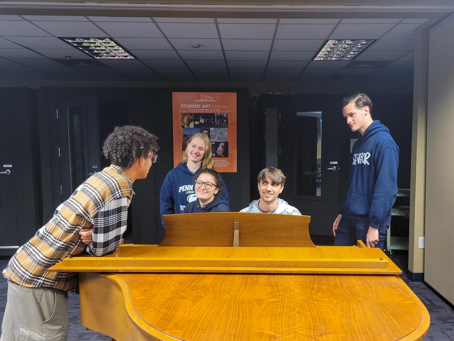 Penn State Lehigh Valley Students talking around the piano in campus music room