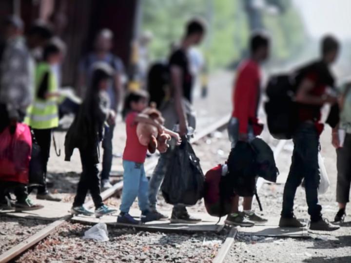 Migrants crossing railroad tracks