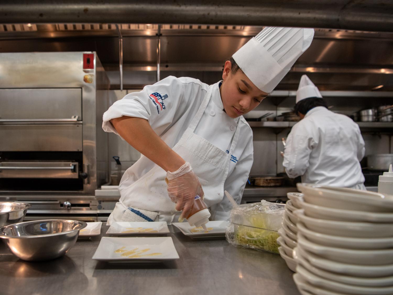 A person dressed in a chef's outfit prepares food in a kitchen
