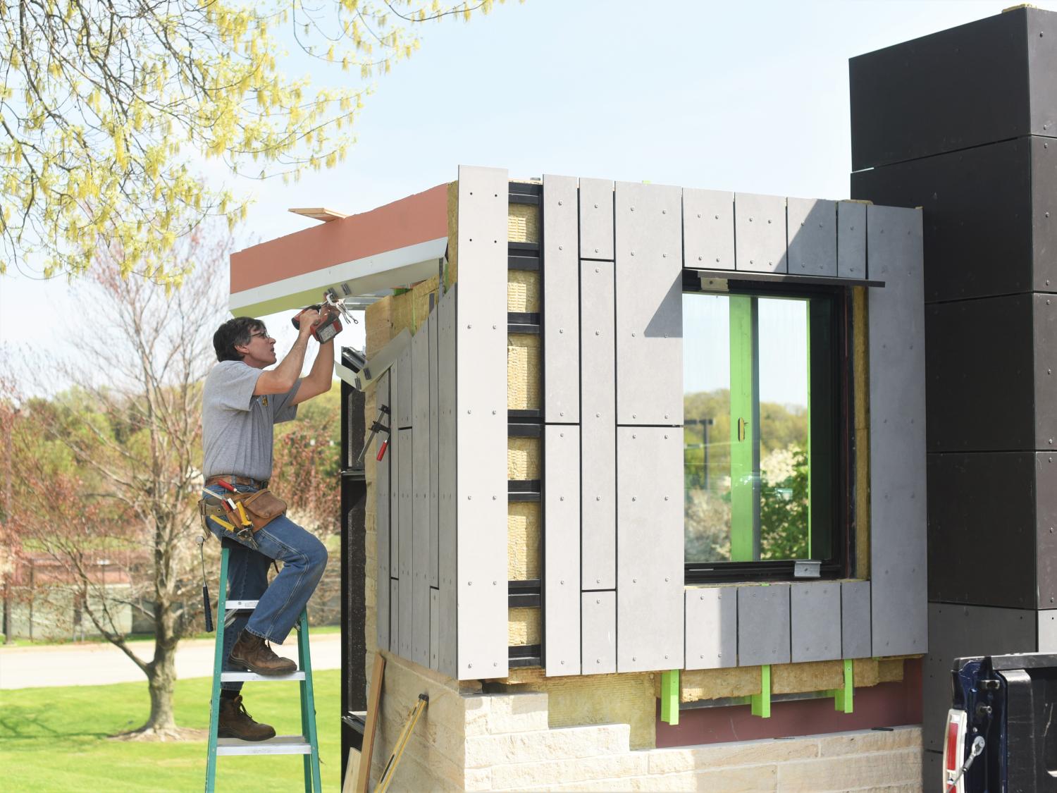 A contractor installs material on an architectural mockup at Penn State Behrend.