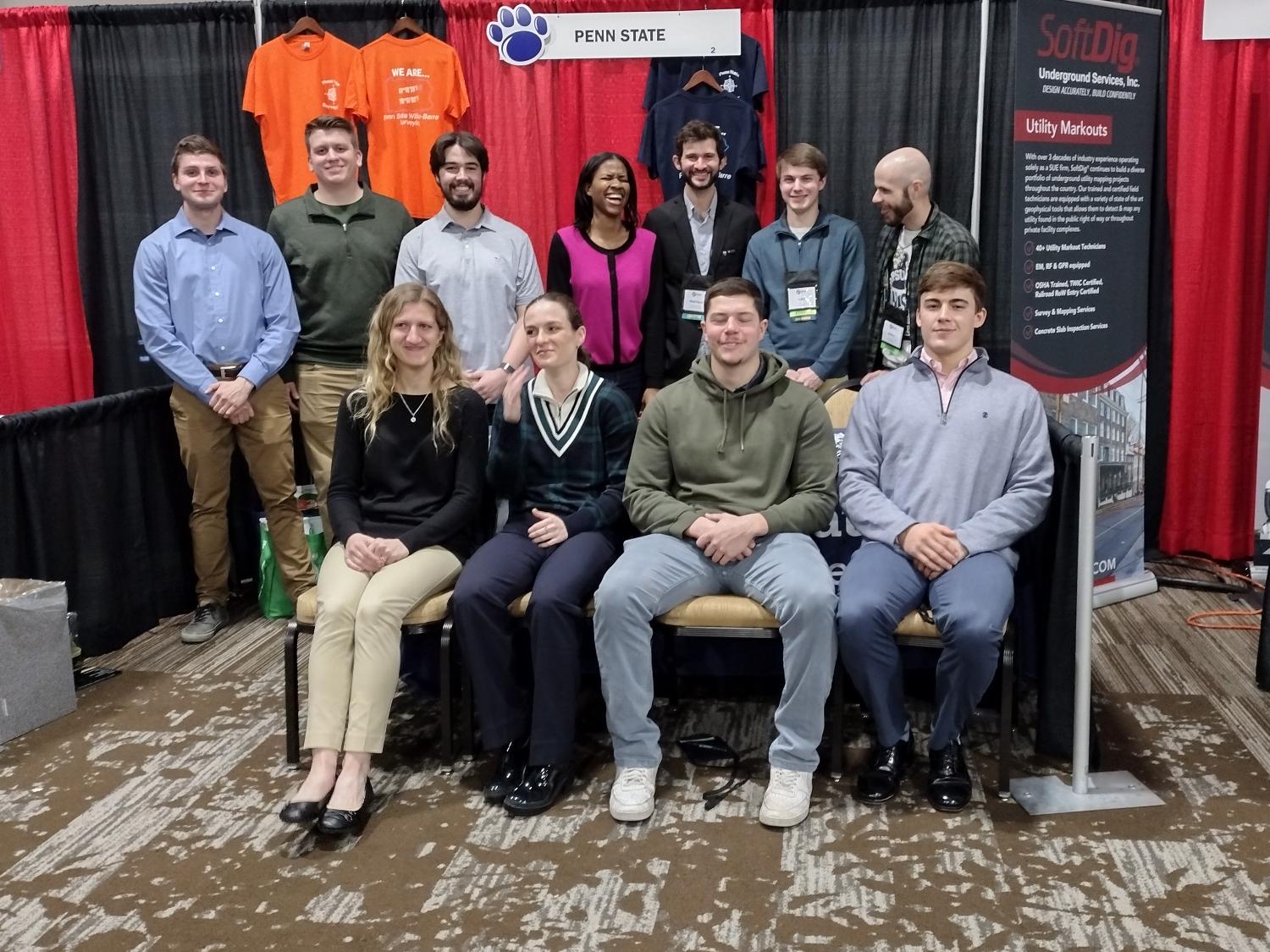 A group of students and faculty at a conference booth