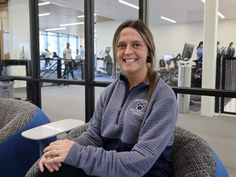 Kelly Wilson, the new campus recreation manager at Penn State Behrend, sits in the lobby of the college's new Erie Hall.