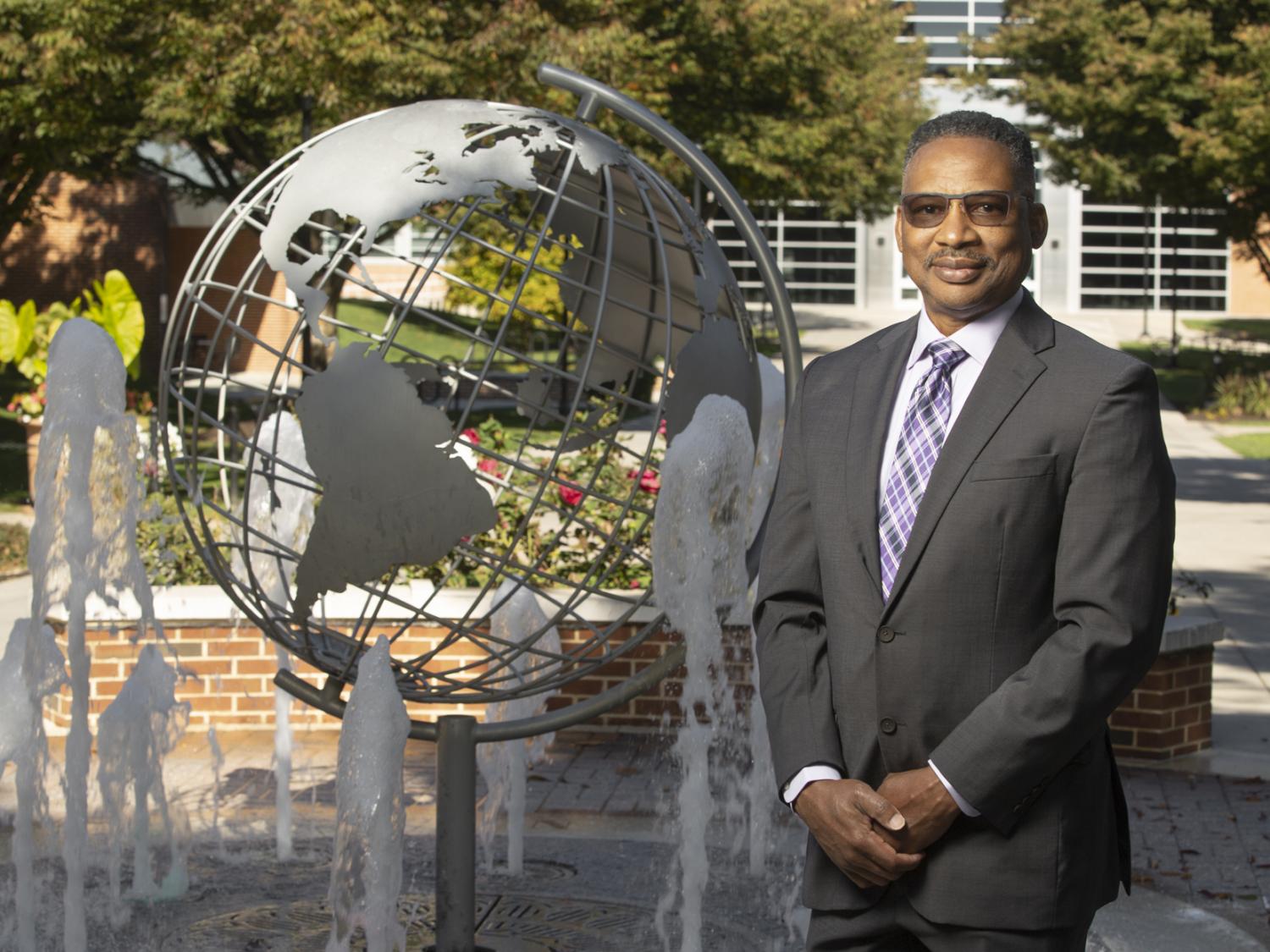 Professor Roderick Lee stands near globe fountain at Penn State Harrisburg