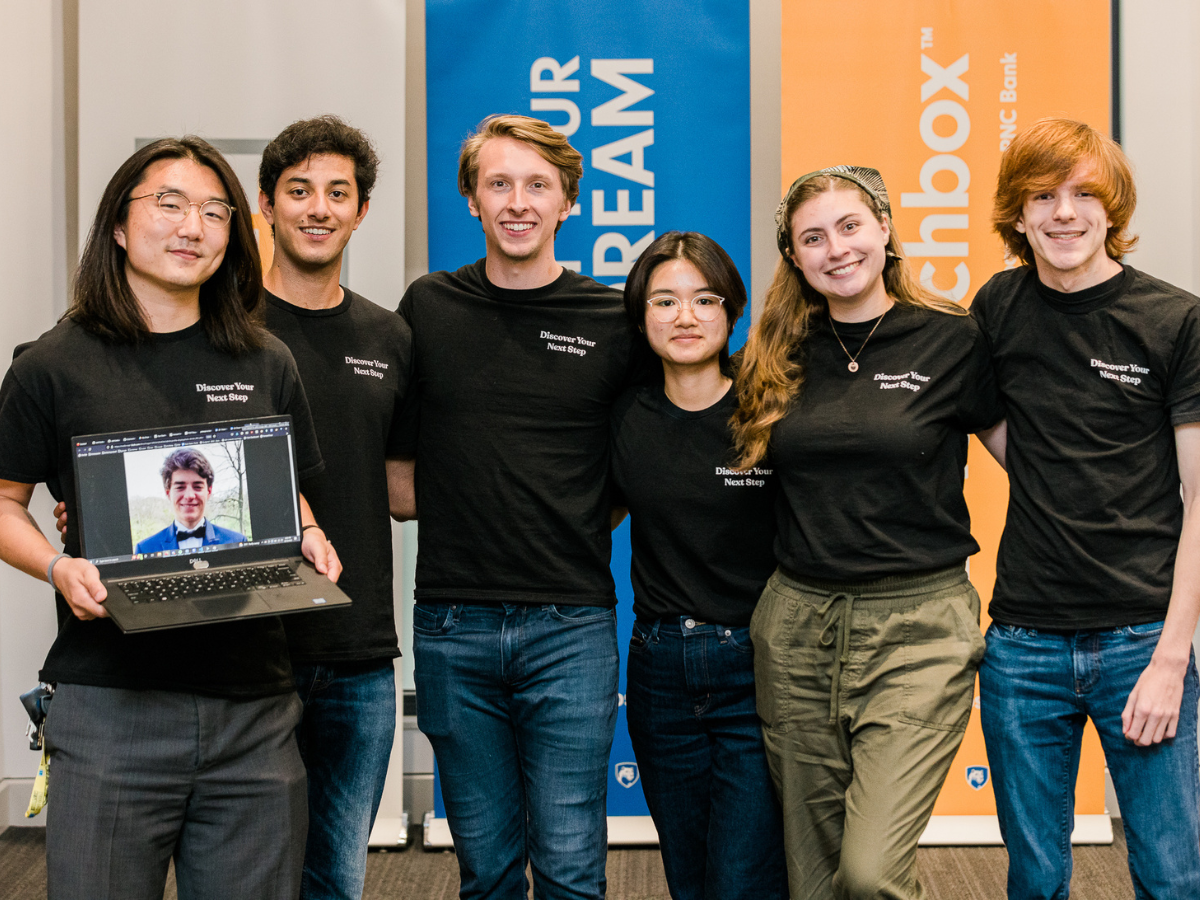 2022 participants in the Invent Penn State Summer Founders Program pose for a group photo in front of Happy Valley LaunchBox powered by PNC Bank signage