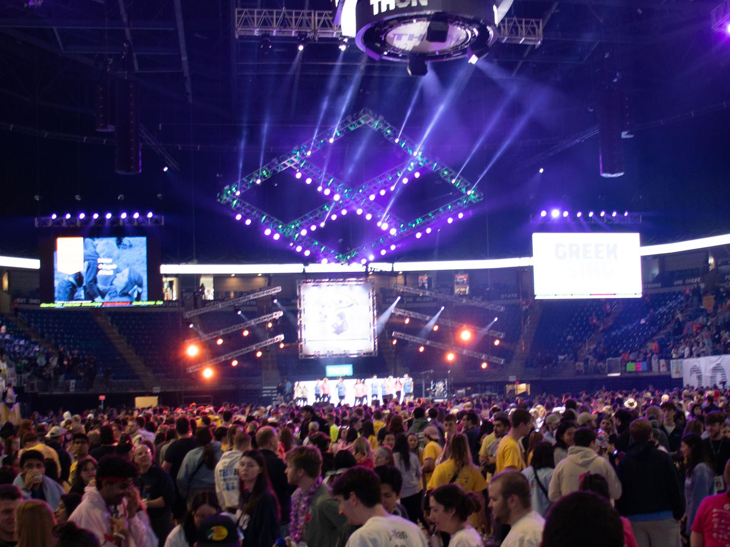 A crowd of people stand on the floor of an arena.