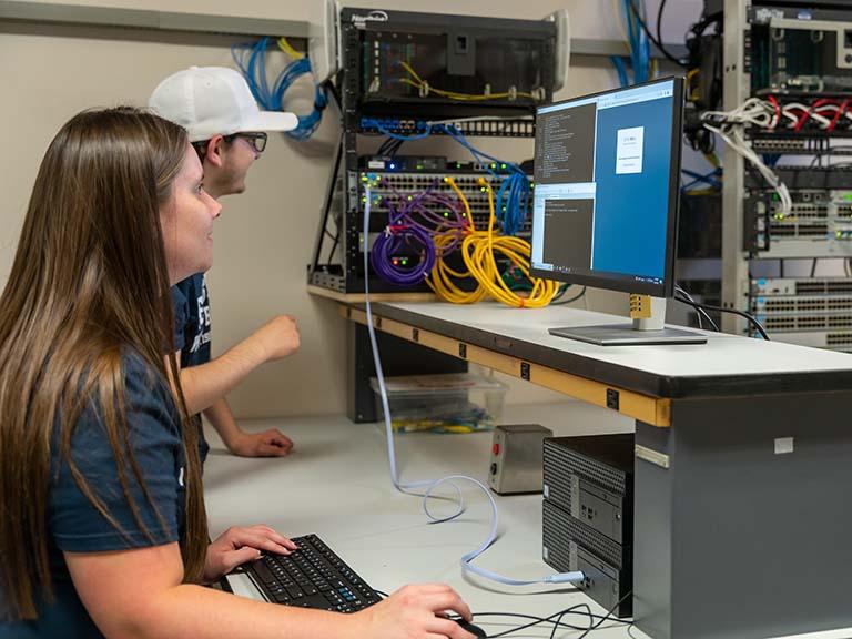 Two students looking at a computer monitor