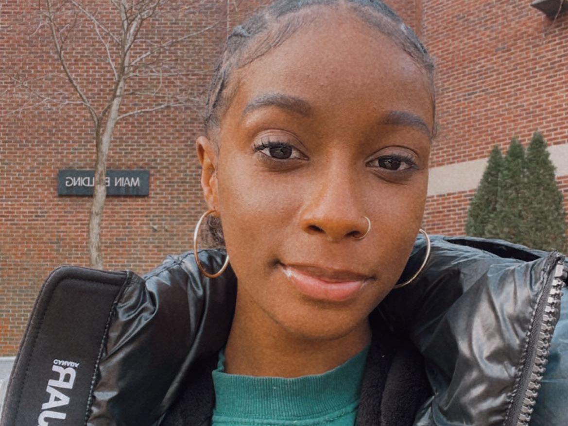 Zhane smiling in front of the Main Building at Brandywine