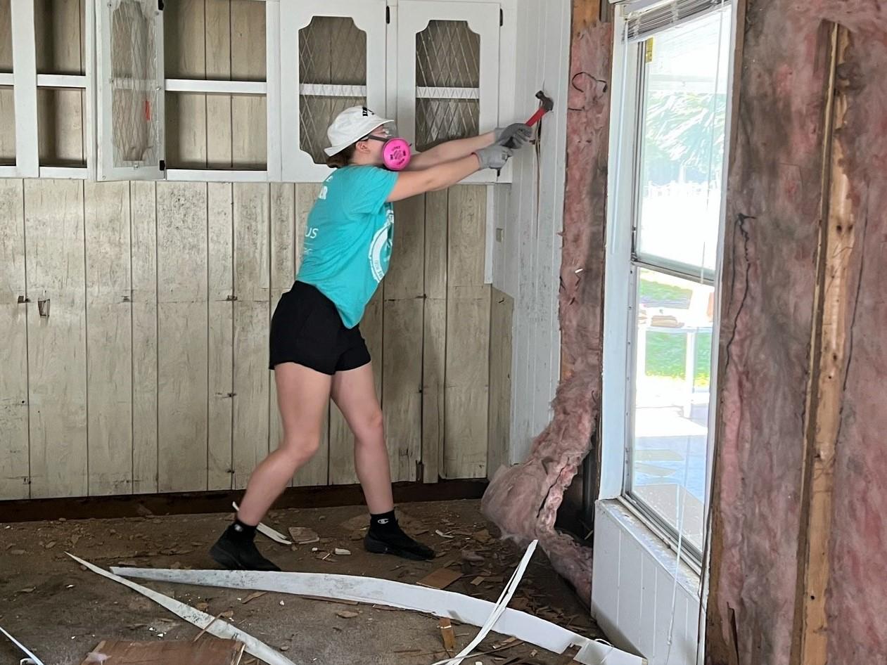 A Penn State Behrend student removes paneling from a storm-damaged home in Fort Myers, Florida, during an Alternative Spring Break program.