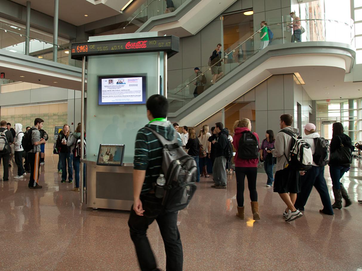 a photo of students walking in the atrium of the Business Building