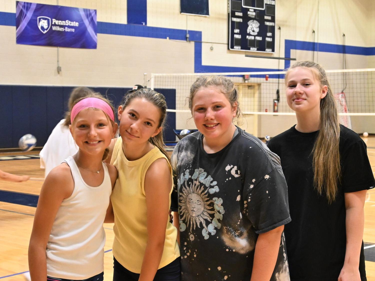 Four girls standing together on a basketball court