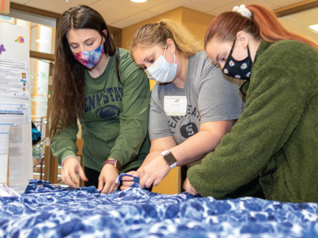 Students tying blankets