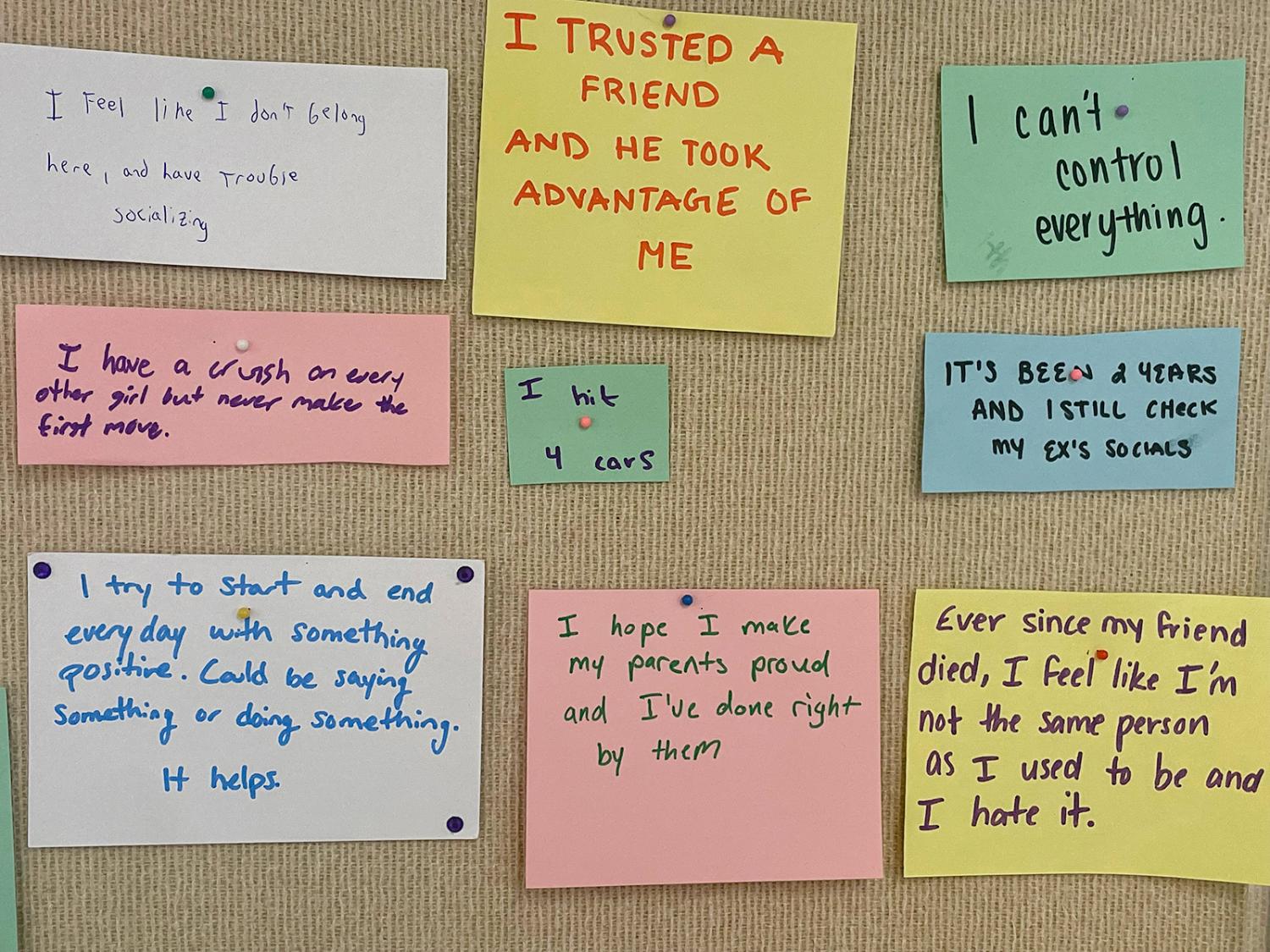 Secrets of individuals written of paper and pinned to a bullertin board