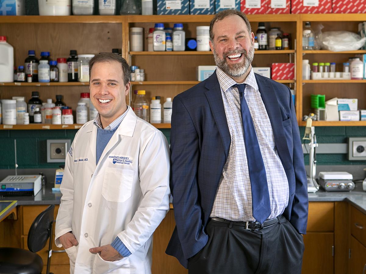 Joshua Warrick and David DeGraff pose for a photo in a laboratory. 