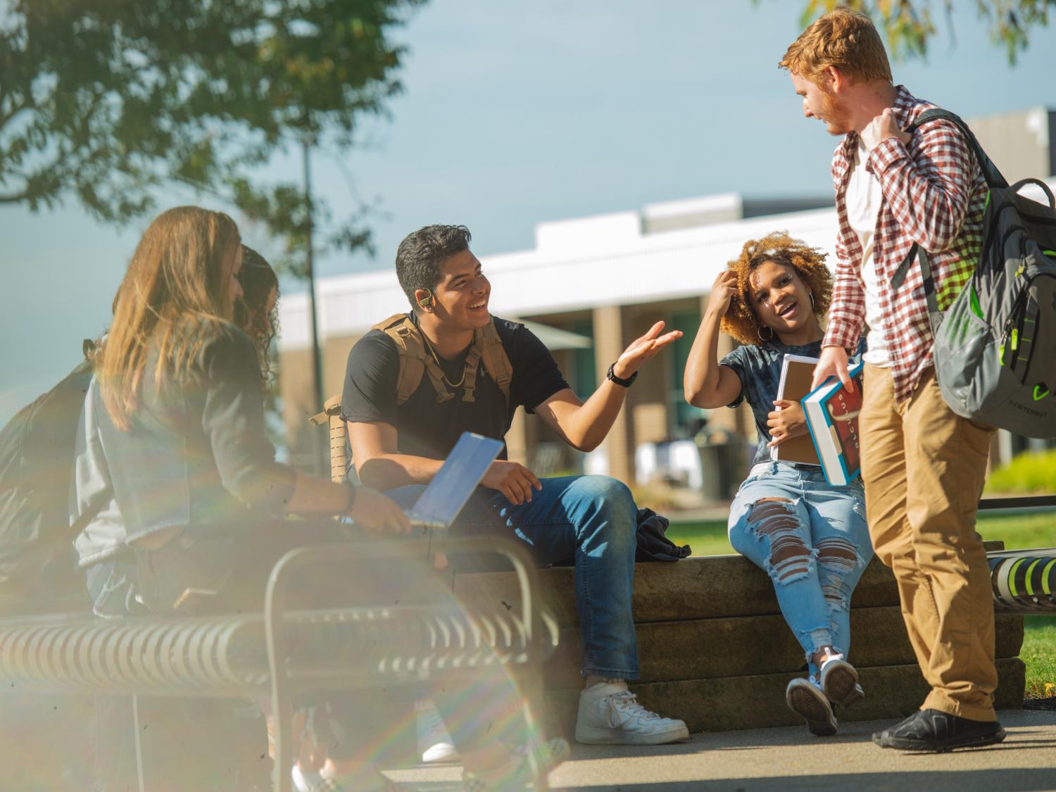 Students gather outside and talk to each other.