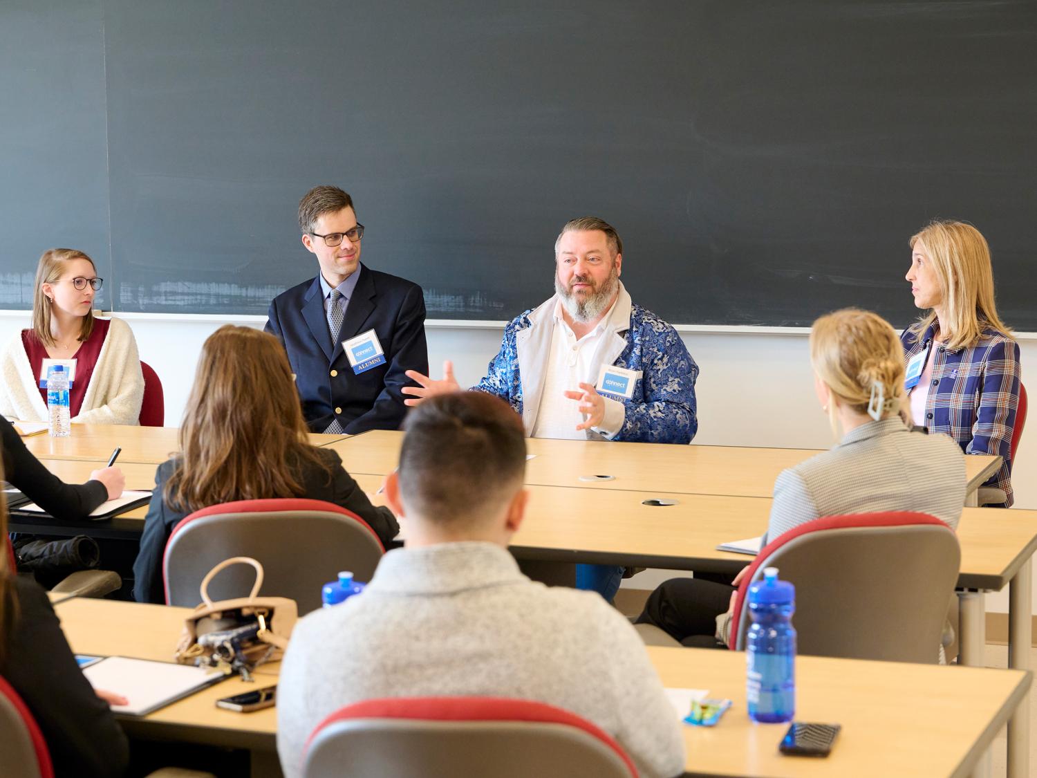four panelists - two women and two men - address a group of students at Connect 2022