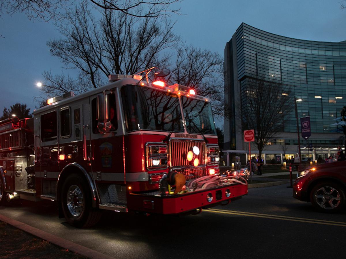 Fire trucks drive in front of a Children's Hospital