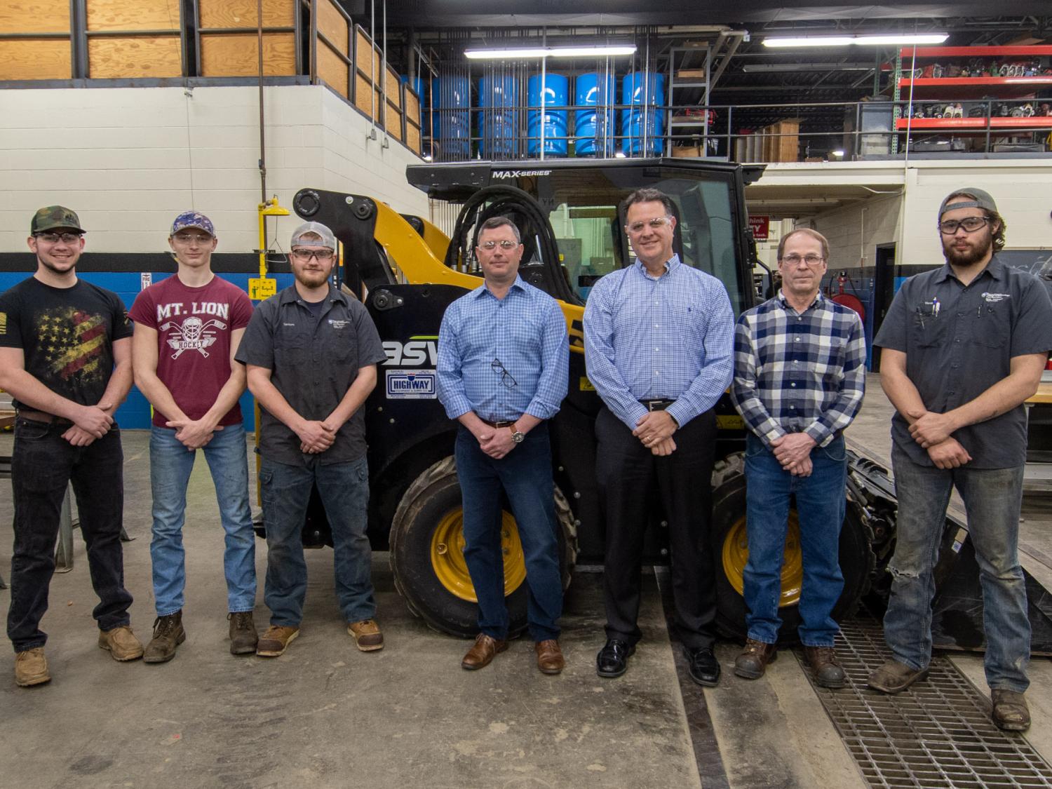 Students stand with donor representatives who donated a skid steer.