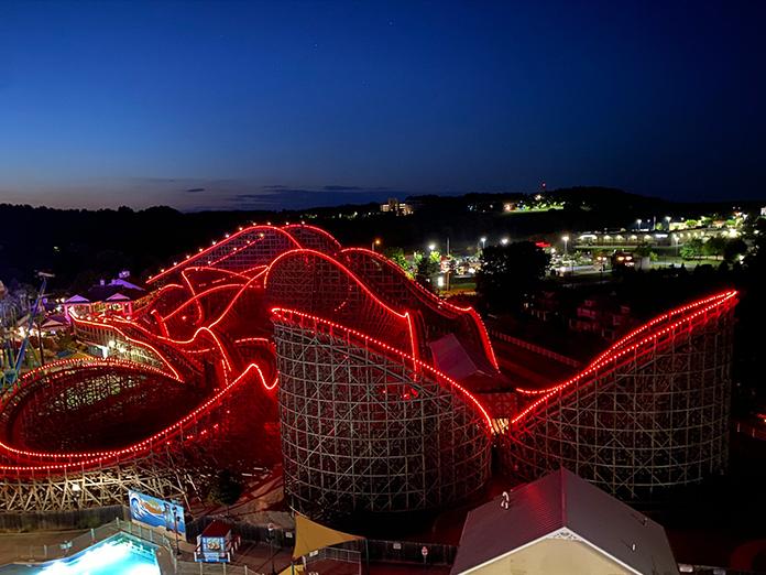 roller coaster with red ligths lining the tracks.