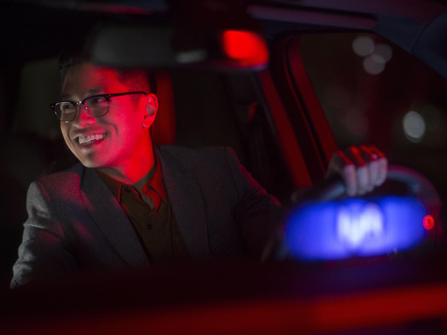 A man driving a vehicle displaying a Lyft badge