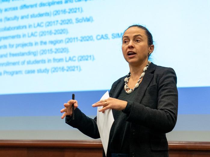 A woman giving a presentation in an auditorium