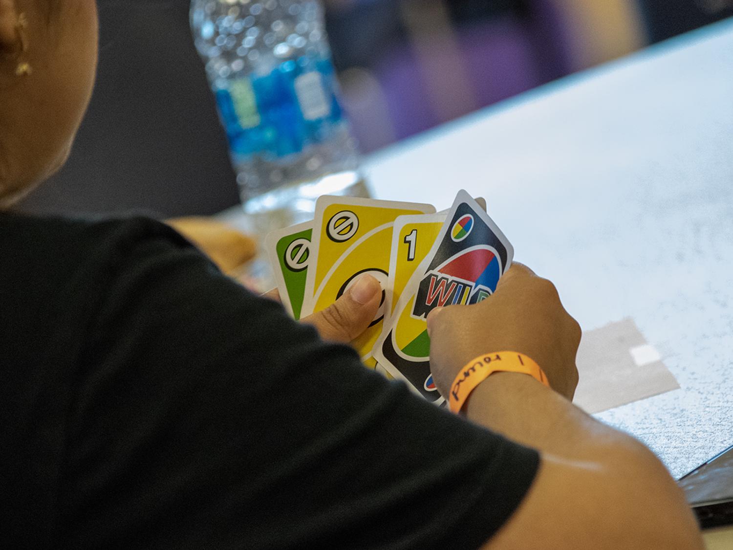 Closeup photo of hands holding Uno cards