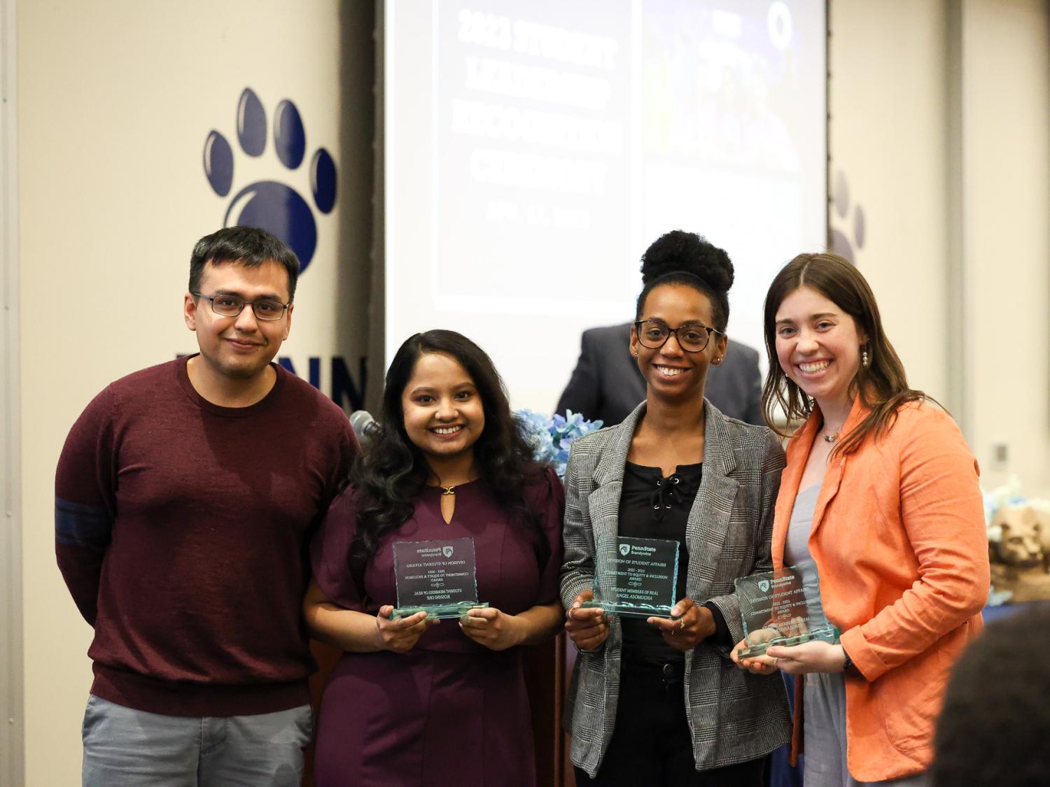 Three women accepting awards from a man