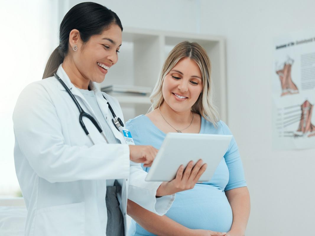 A doctor consults with a pregnant patient in a clinic.
