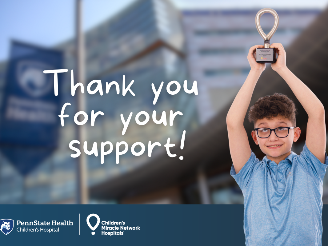 A young boy holds a trophy high in the air. The backdrop is a blurred photo of Penn State Health Children's Hospital with the words "Thank you for your support!" are placed. The Children's Hospital and CMN logos are at the bottom.