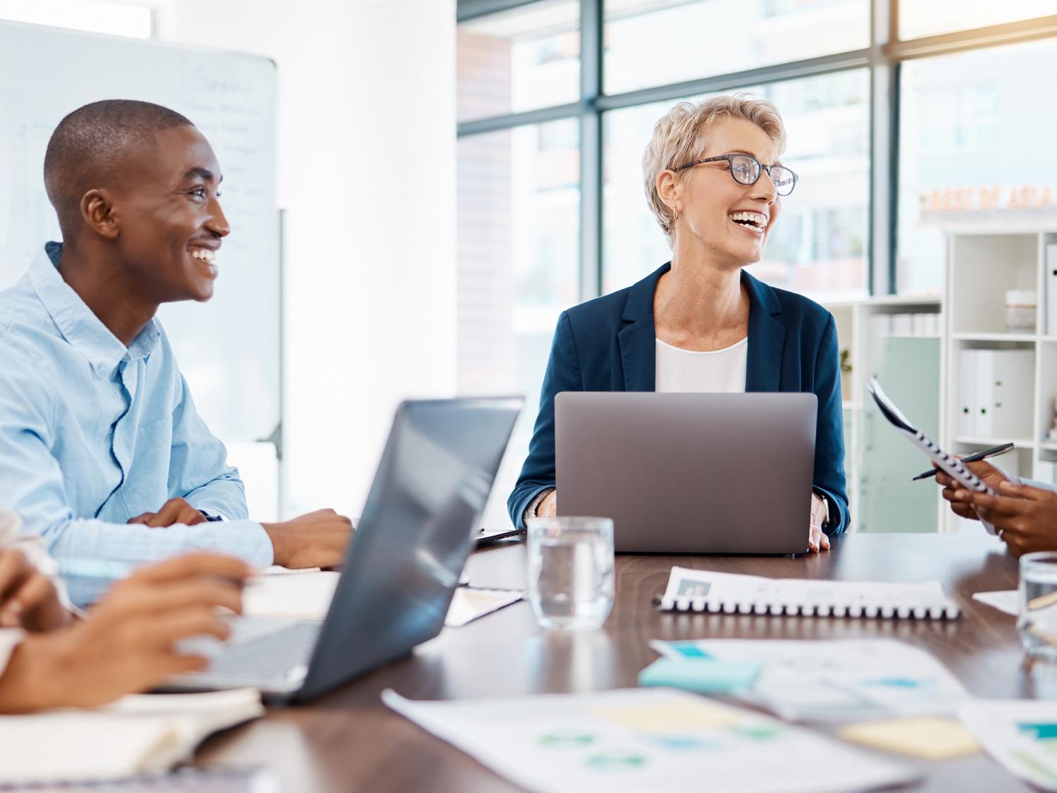 A group of people sit at table in an office space.
