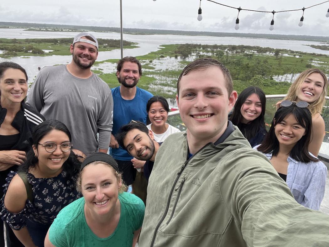 A male student is taking a selfie with his classmates and teacher during their time in Peru. 