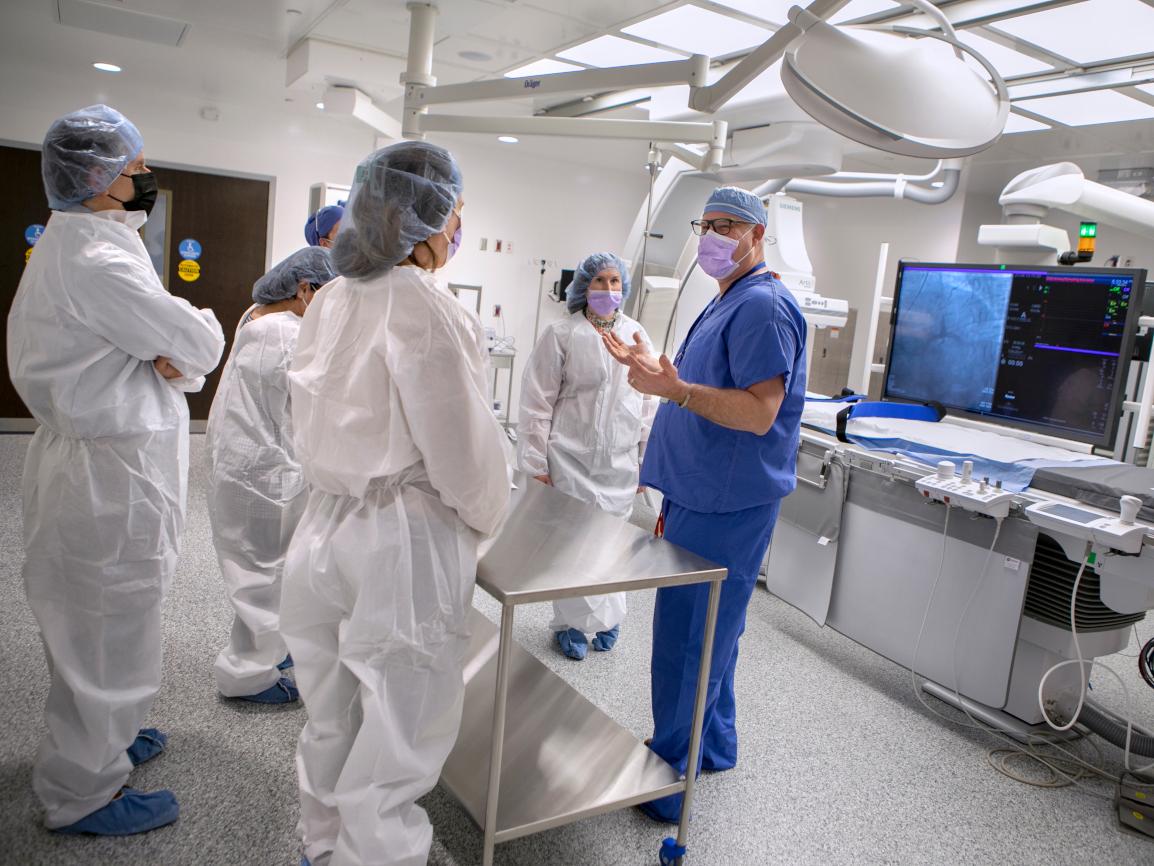A doctor shows a group of people a new cardiac catheterization lab
