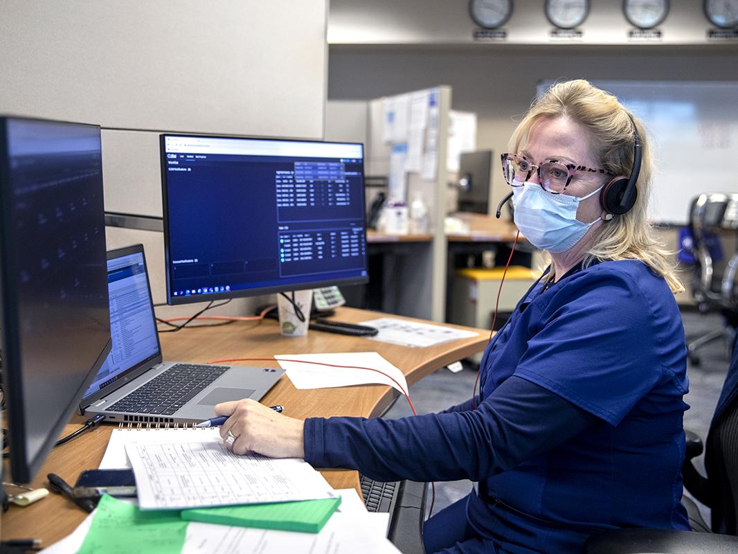 Susan Richwine, a registered nurse in Penn State Health’s Virtual Intensive Care Unit, sits at a desk viewing multiple computer screens that allow her remotely to monitor the conditions of patients in intensive care.
