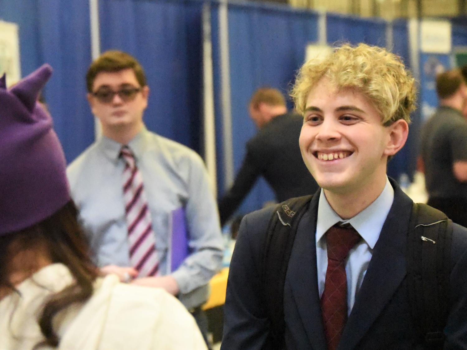 A student smiles while talking with a recruiter at Penn State Behrend's spring Career and Internship Fair.