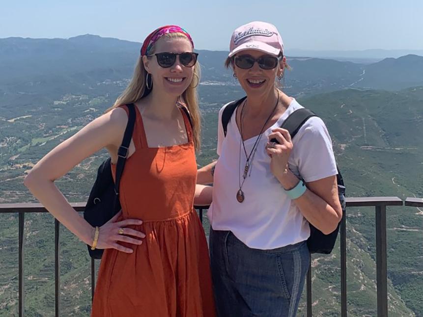 A photo of Karin Strom and Nancy Mahon on a balcony with a green valley in the background.