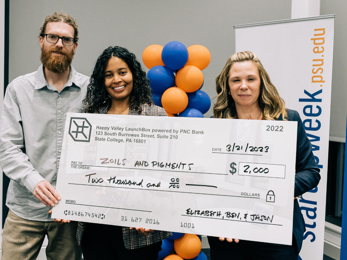 Zoils & Pigments co-founders stand with Happy Valley LaunchBox powered by PNC Bank director holding an oversized check awarded to Zoils & Pigments