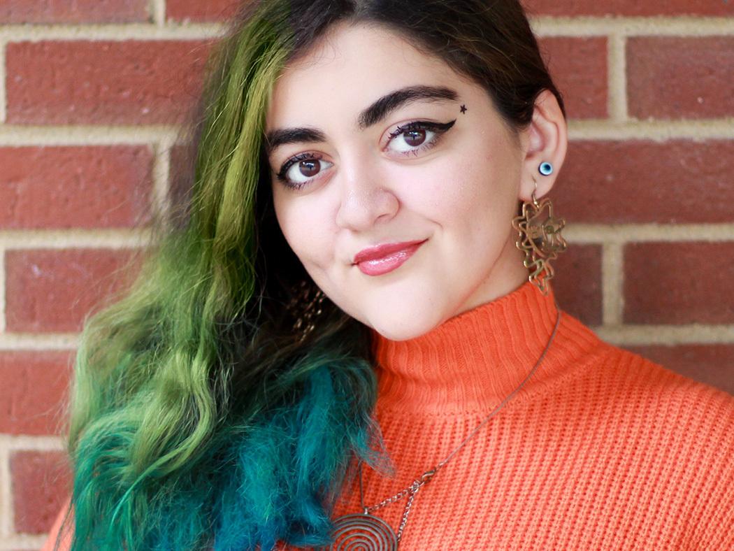 Aysan Jafarzadeh's headshot against a brick background.