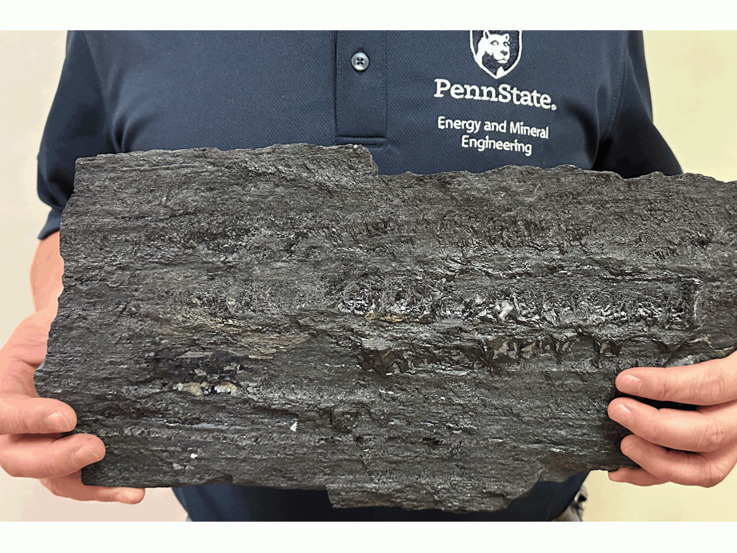 A Penn State researcher holds a piece of coal 