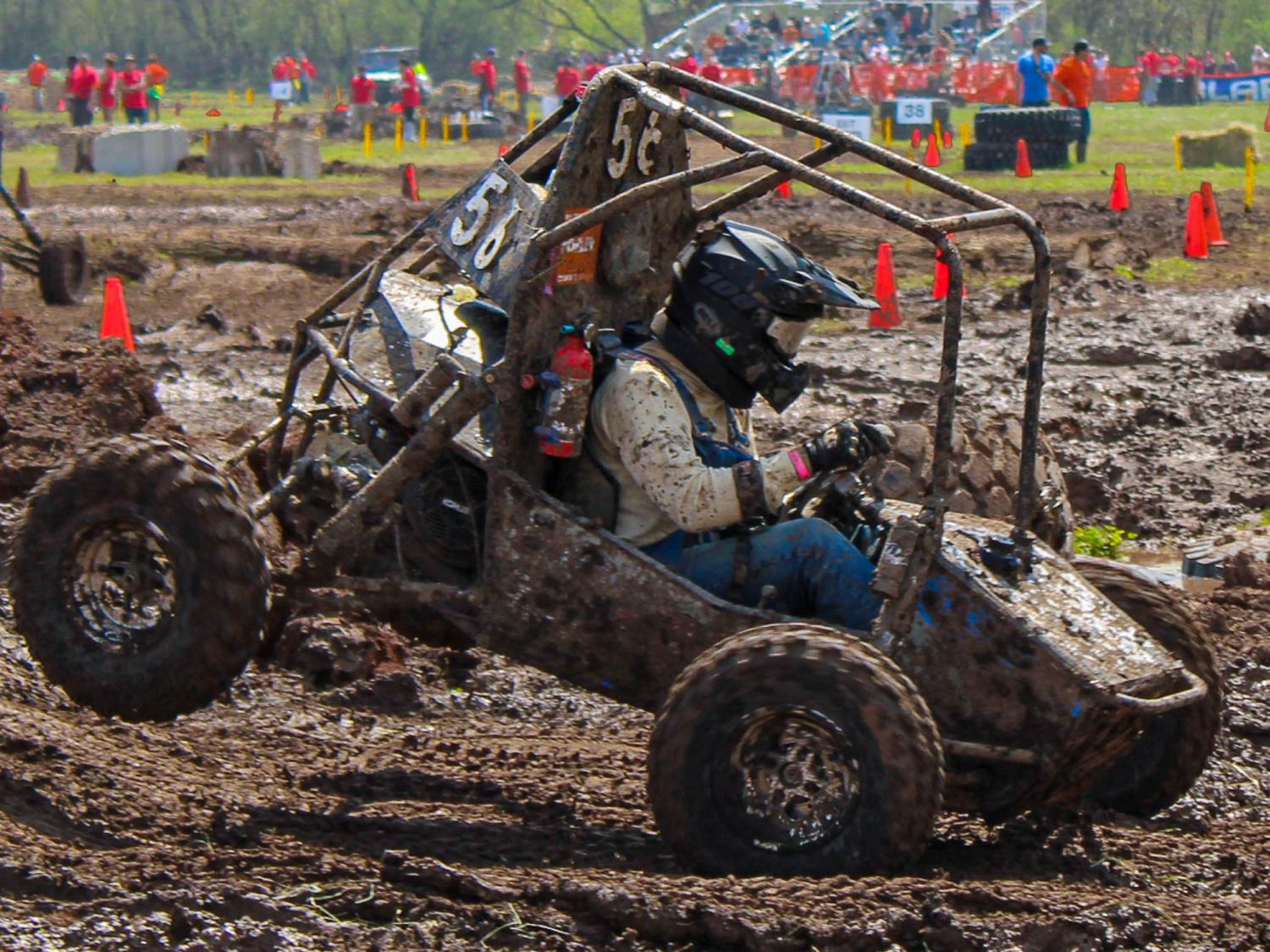 An all terrain vehicle being driven on a muddy course
