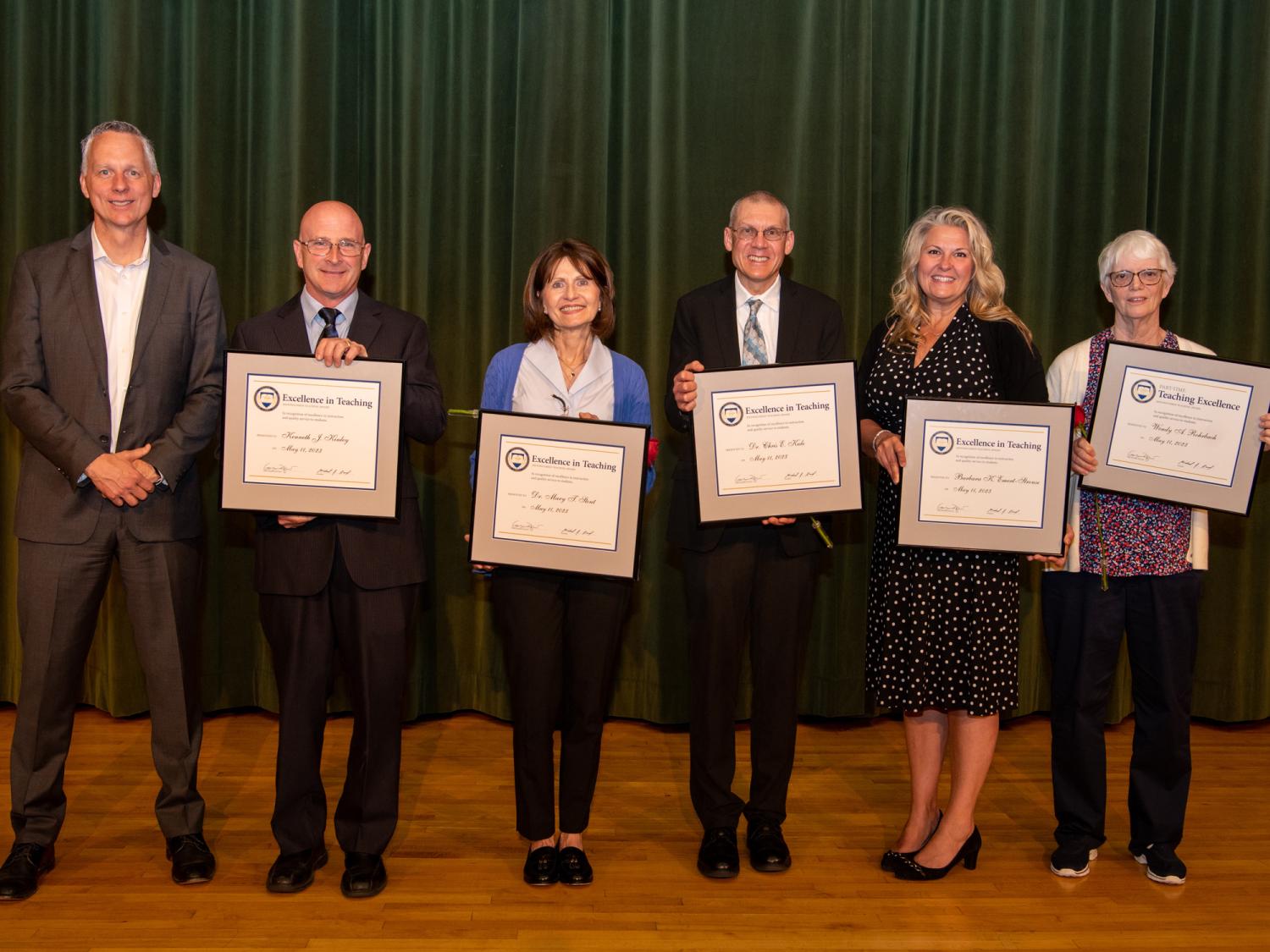 A group of people hold up certificates