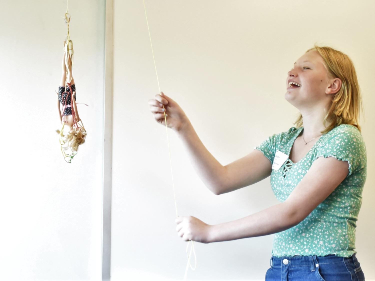 A female student drops a Barbie doll on a bungee cord at Penn State Behrend's Math Options Career Day.