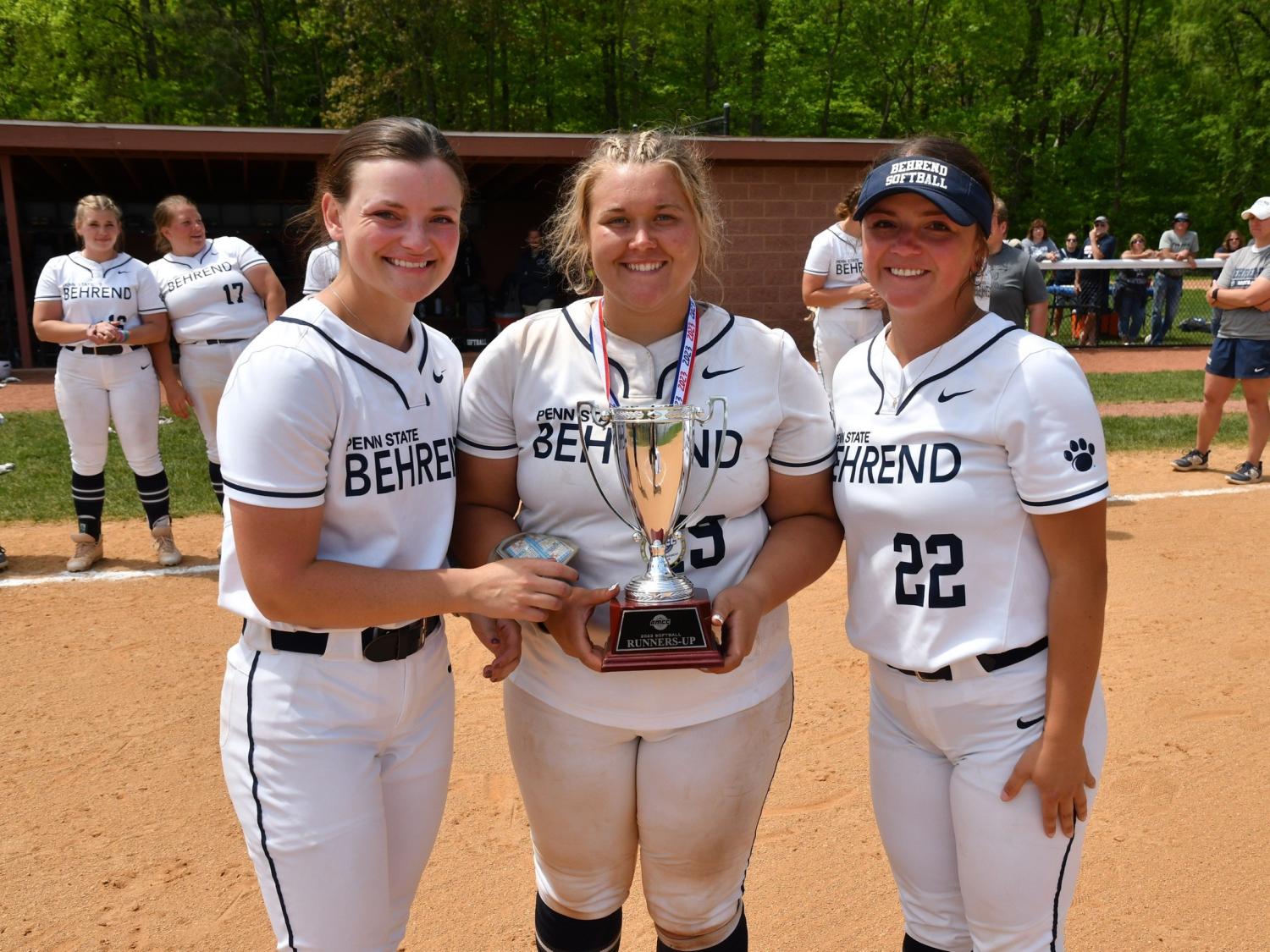 Three Penn State Behrend softball players hold the AMCC runner-up trophy.