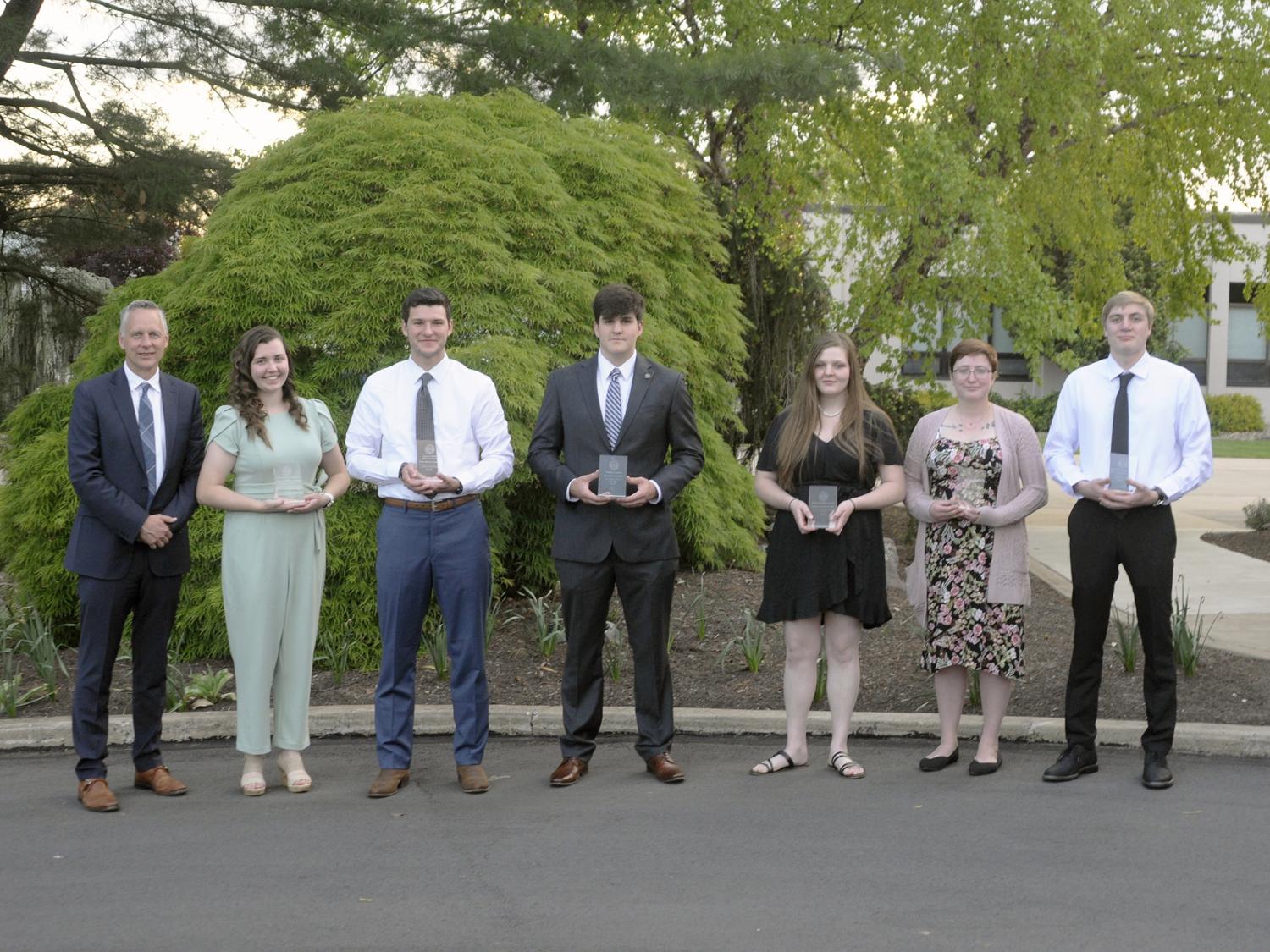 Seven students standing in a row for a photo
