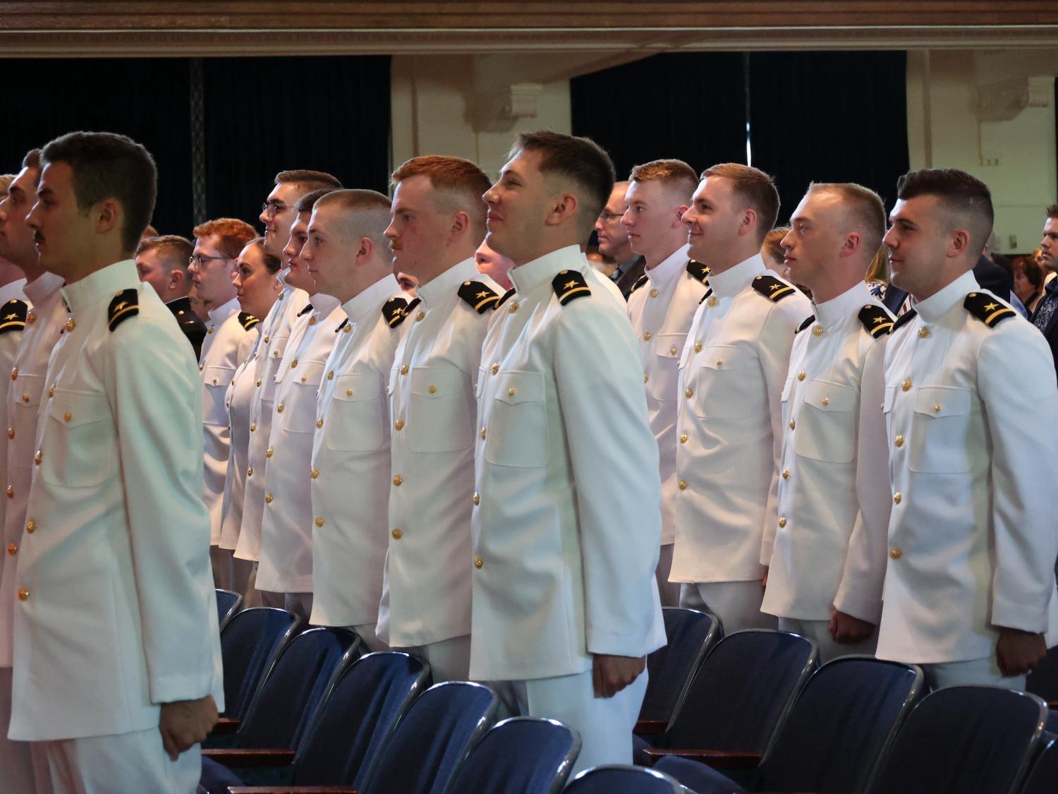 Recent NROTC graduates stand at attention in rows