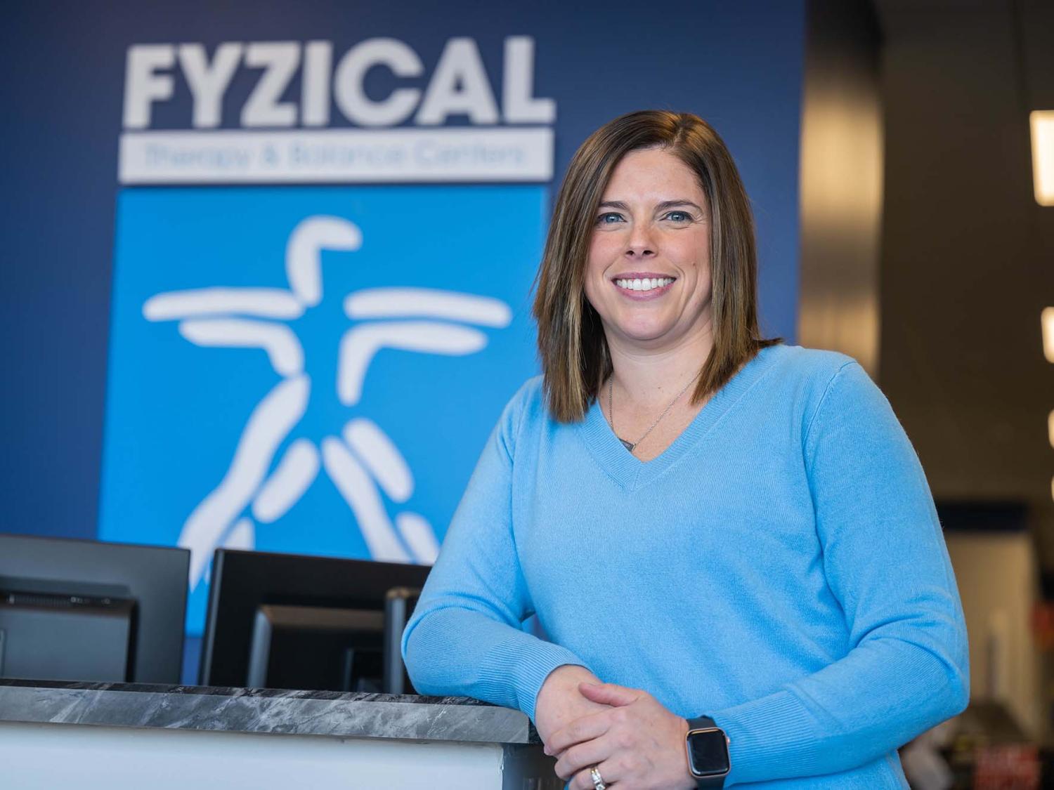Penn State Behrend alumna Karla (Murray) Mazza leans on a counter at a physical therapy clinic.