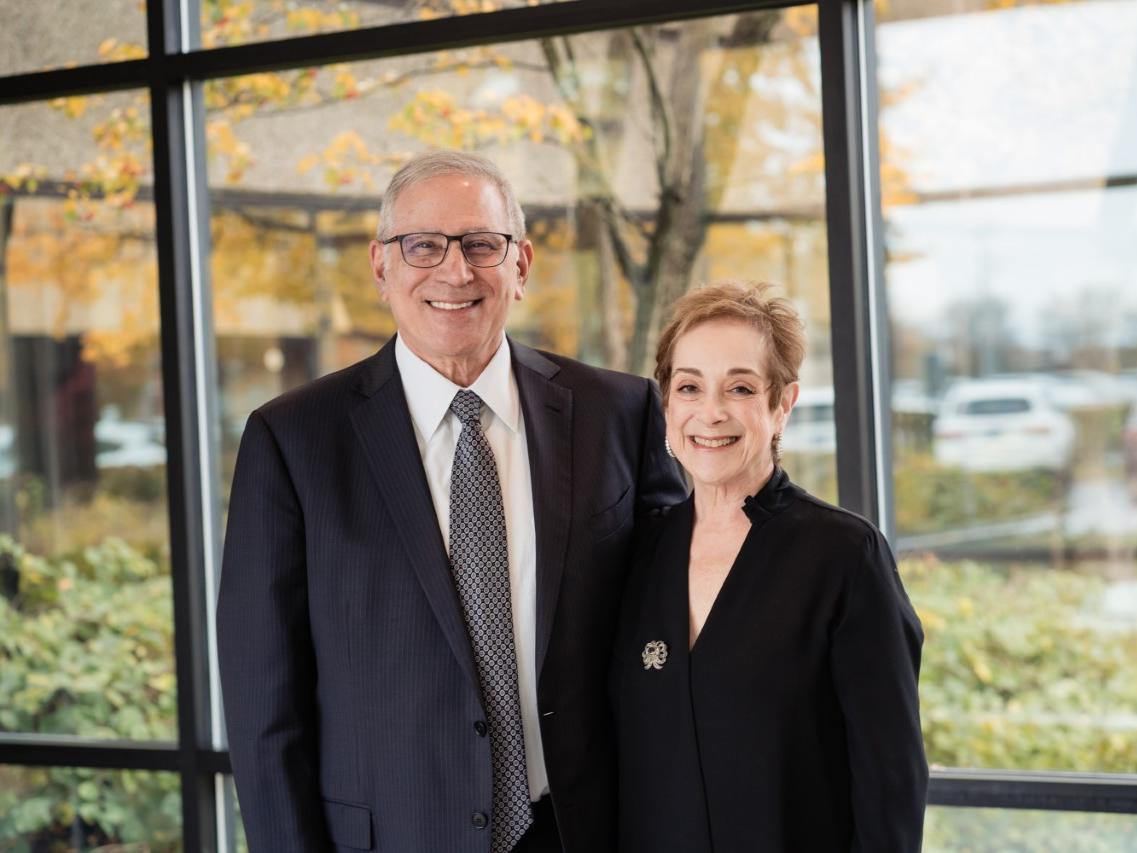 photo of couple standing in front of wall of windows